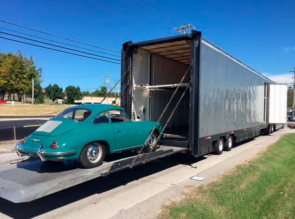 A car being loaded into an enclosed trailer